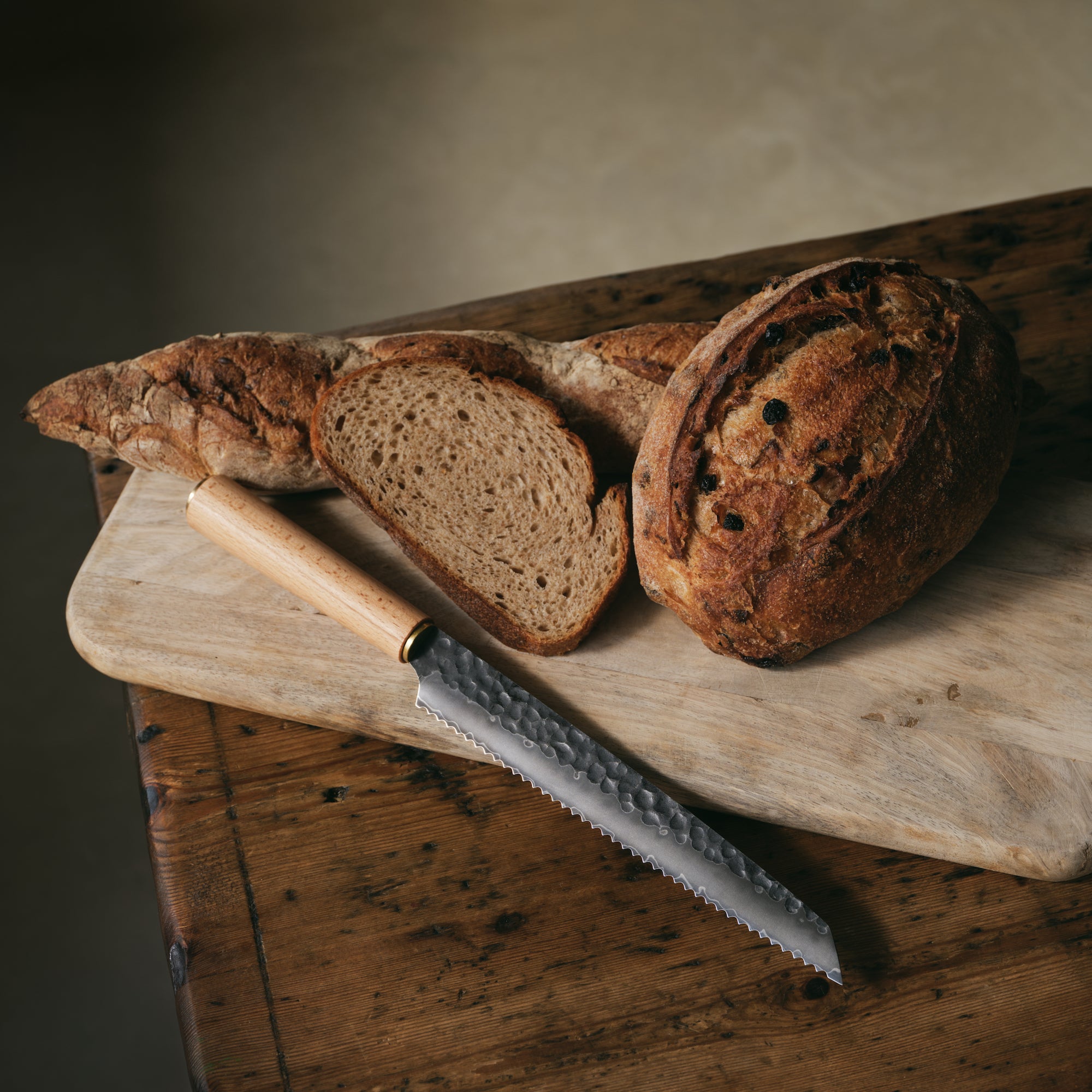 Katto Bread Knife with beech wood handle, sitting alongside some sliced sourdough bread